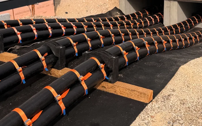 High-voltage cables secured with orange straps at a cable entry
