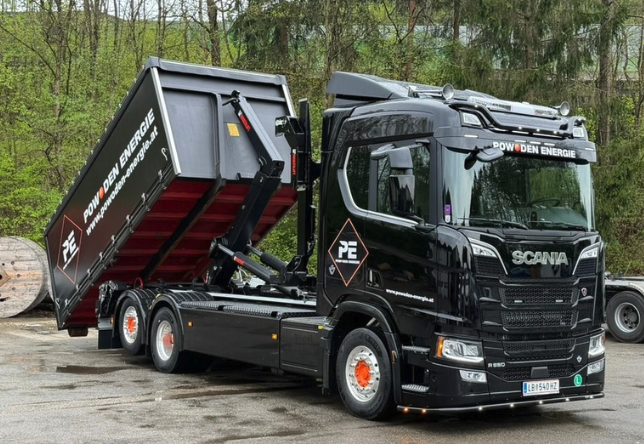 Black POWODEN Energie truck with a hook-lift container