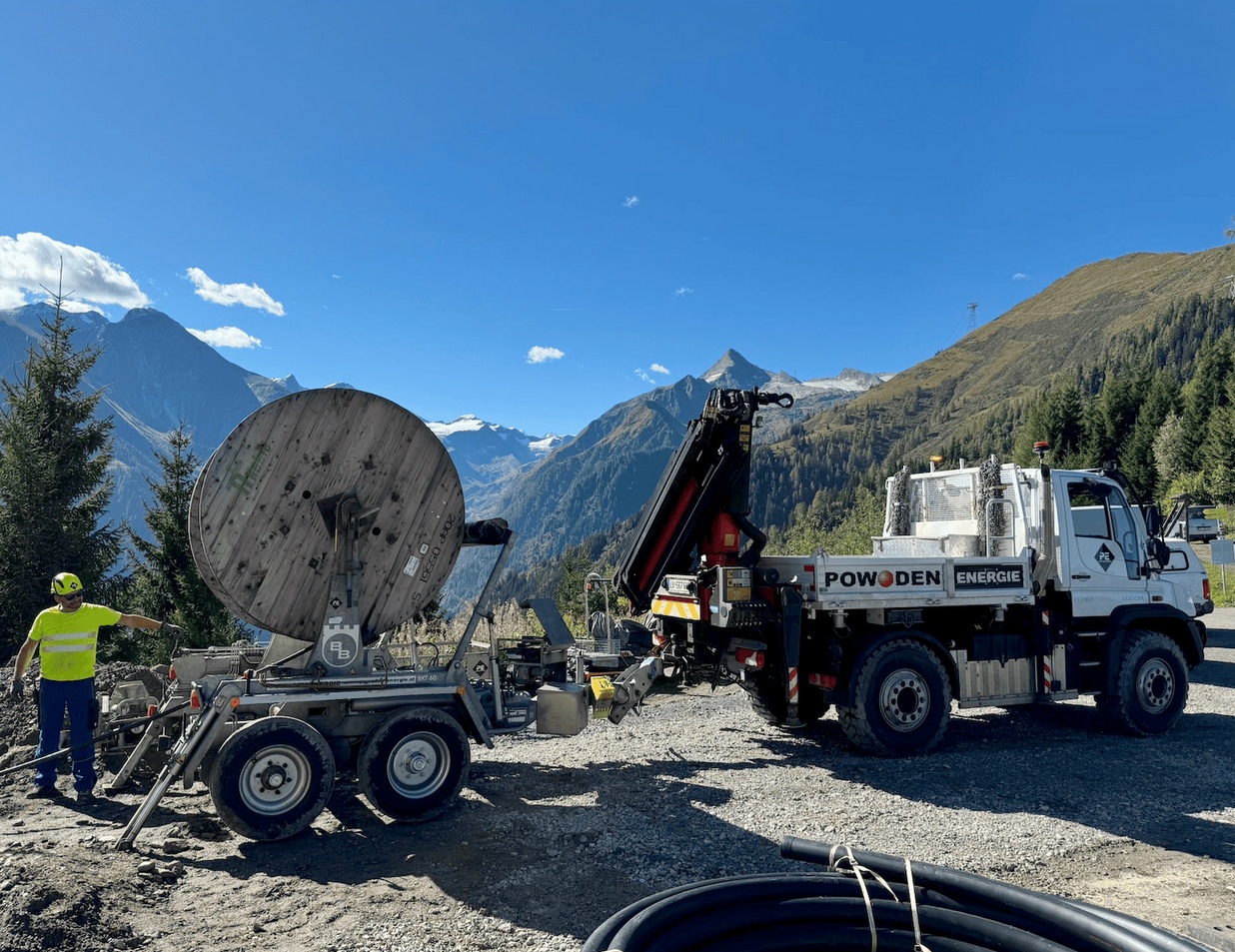 POWODEN Energie Unimog with loading crane and cable drum trailer in alpine terrain