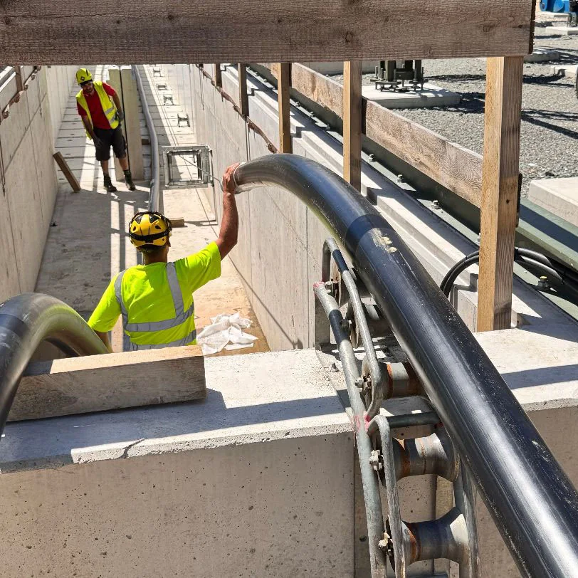 Mitarbeitende verlegen Baueinsatzkabel in einer Kabeltrasse