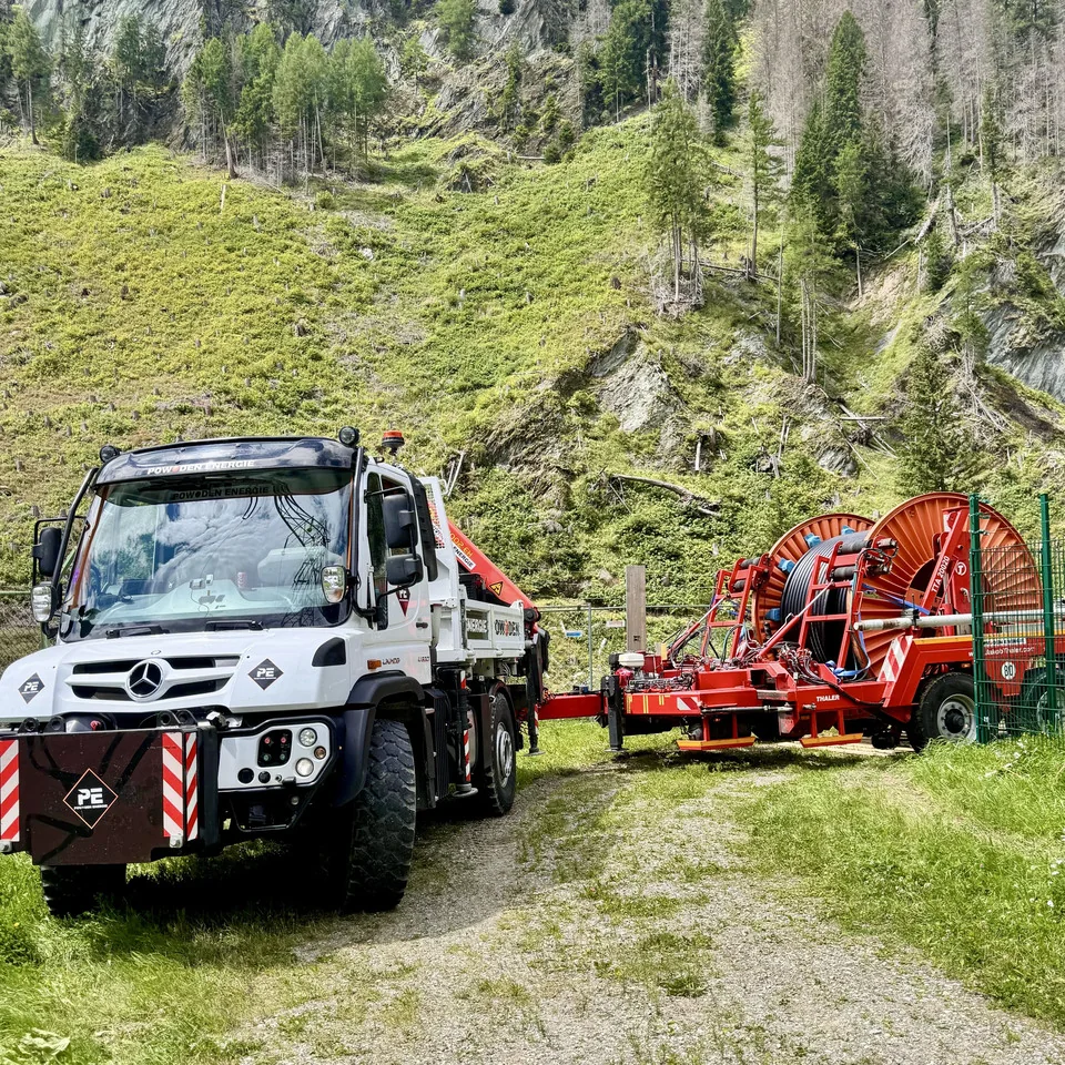 POWODEN-Energie-Unimog mit Kabelanhänger im alpinen Gelände